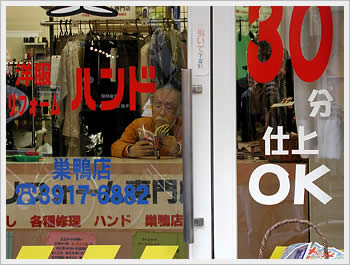 Owner of a dry cleaning store reading manga comic, Sugamo: click for larger image (60K)