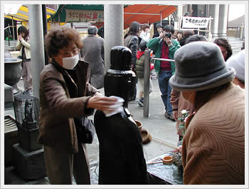 Women washing Togenuki Jizo, Sugamo: click for larger image (52K)